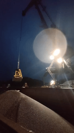 Nighttime crane operations unload gravel at Shalsky port facility