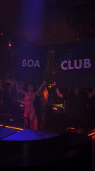 DJ booth and sign-holders inside a Patong nightclub