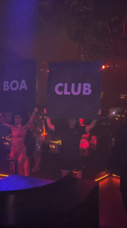 DJ booth and sign-holders inside a Patong nightclub