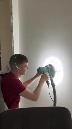 Man renovates interior using power sander in Verkhnyaya Pyshma