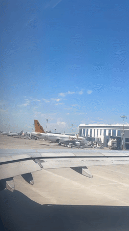 Passenger films aircraft wing and tarmac at Aksu airport