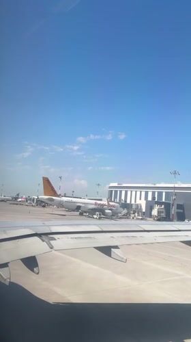 Passenger films aircraft wing and tarmac at Aksu airport