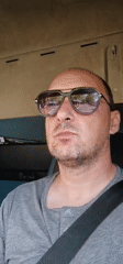 Driver in sunglasses operates truck in Bulgarian village