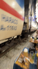 Eating and drinking inches from active trains on Hanoi's Train Street