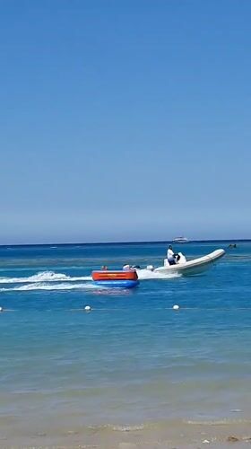 Motorboat pulls inflatable tube in sunny Hurghada waters