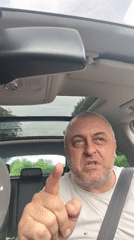 Man makes pointing gestures while seated in car in Clopton