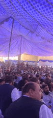 Large outdoor gathering held under tent in Panjpai, Pakistan