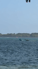 Paddleboarding, kiteboarding, and outrigger boats at Sanur Beach