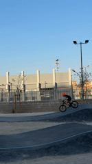 Child rides BMX bike on Valencia skate park pump track