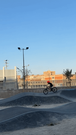 Child rides BMX bike on Valencia skate park pump track