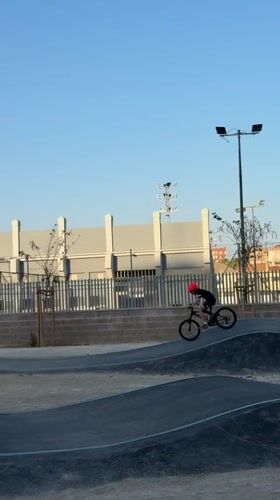 Child rides BMX bike on Valencia skate park pump track