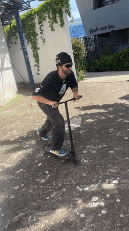 Man performs scooter tricks in Bron park
