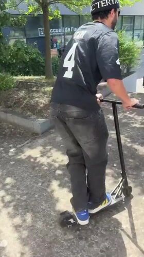 Man performs scooter tricks in Bron park