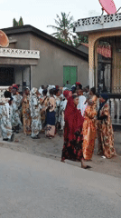 Women in traditional dress gather on Dar es Salaam street