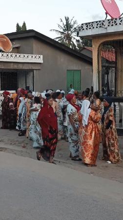 Women in traditional dress gather on Dar es Salaam street