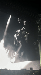 Concert screen displays black-and-white performer footage in Indio