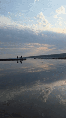 Three people gather on lake pier in Chaikovsky