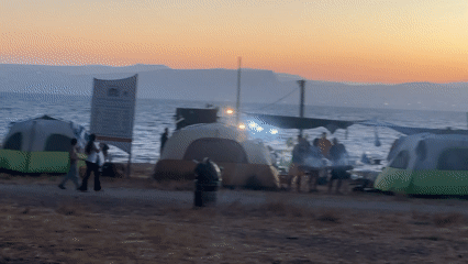 Campers gather at sunset along Sea of Galilee shore