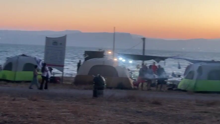 Campers gather at sunset along Sea of Galilee shore