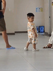 Child in pajamas, adult at counter observed indoors