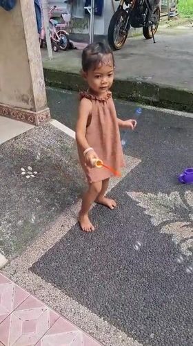 Girl in brown dress recorded standing barefoot in Penebel