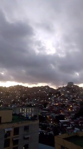 Overcast dusk settles over a Caracas hillside neighborhood