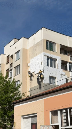 Workers perform facade maintenance on Haskovo building
