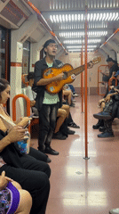 Street musician performs guitar on Buenos Aires subway car