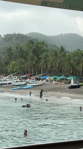 Children play with bodyboards at Senggigi Beach, Indonesia