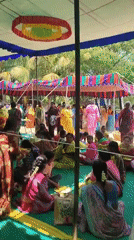 Large gathering of women, children under tents observed