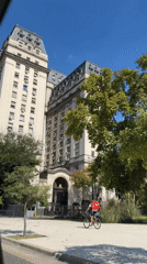 Delivery cyclist rides sidewalk near Casa Rosada in Buenos Aires