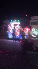 Decorated light-covered vehicle draws crowds on Orai street