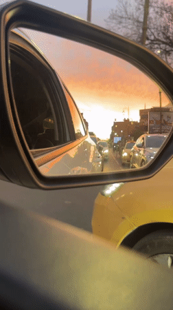 Marrakesh driver captures sunset in side mirror during evening traffic