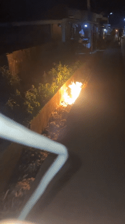 Trash fires burn in concrete ditches in Akwanga, Nigeria