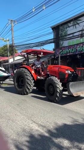 Tractor tows jet skis on road in Thailand