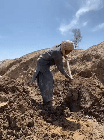 Construction workers dig trenches in Kandahar excavation project