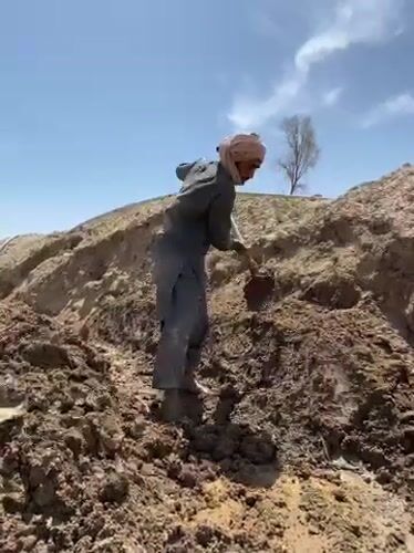 Construction workers dig trenches in Kandahar excavation project