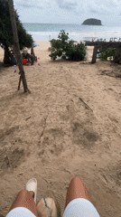 Beach visitor enjoys coconut drink at Kata Beach, Thailand