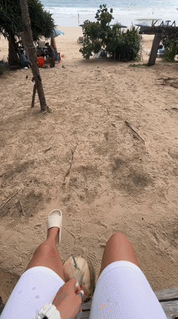 Beach visitor enjoys coconut drink at Kata Beach, Thailand