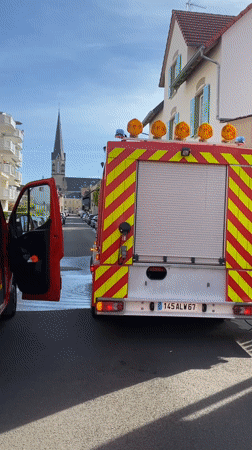 Fire trucks stationed on wet street in Bischheim France