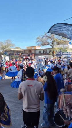 Elaborate costumed procession fills a sunny town square