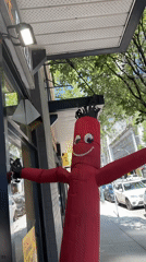 Inflatable tube man and glass towers on a New Westminster street