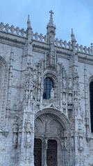 Exploring Jerónimos Monastery's Manueline architecture on a cloudy evening