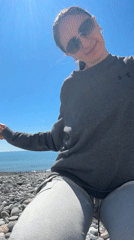 Woman makes peace sign on sunny Sochi beach