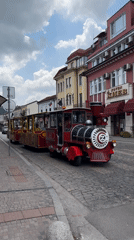 Tourist train rolling through central Veliko Tarnovo on a summer morning