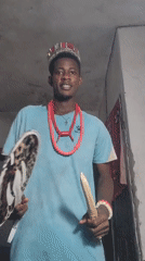 Ceremonial regalia and crown in a dimly lit Nigerian room