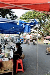 Street vendor at a glass-case cart in Malang, Indonesia