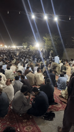 Large traditional nighttime gathering in Quetta, hundreds seated outdoors
