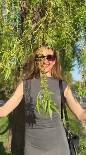Woman enjoys spring blooms in Kryvyi Rih park area