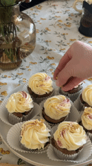 Home baker decorates cupcakes with frosting in Krasnoyarsk